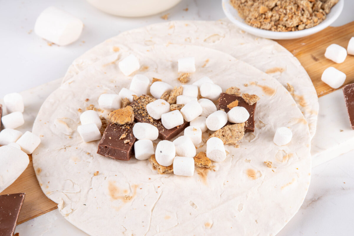 tortillas topped with chocolate, marshmallows and crushed graham crackers