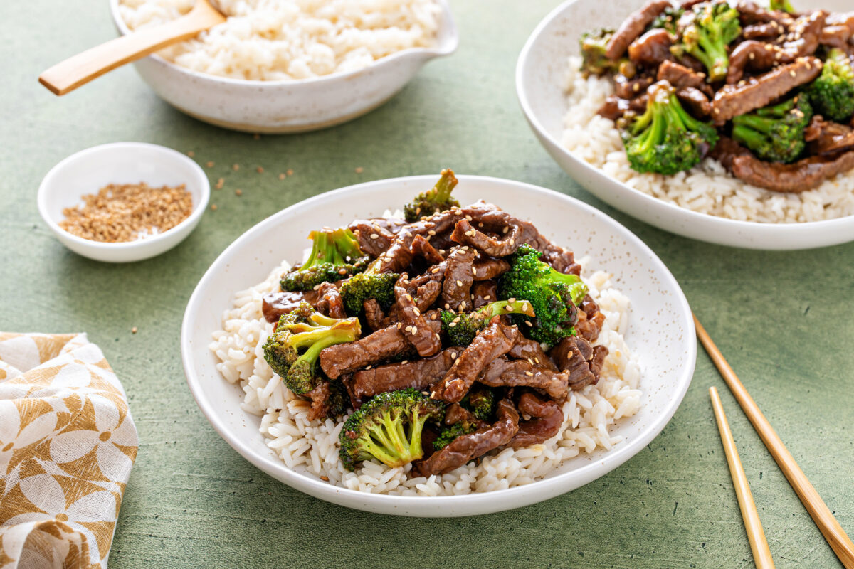 Beef and broccoli stir fry served over rice with sesame seeds