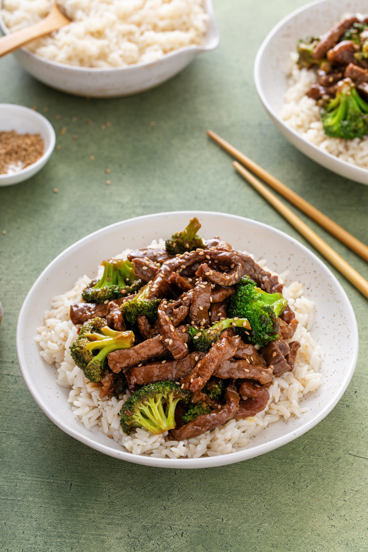 Beef and broccoli stir fry served over rice with sesame seeds
