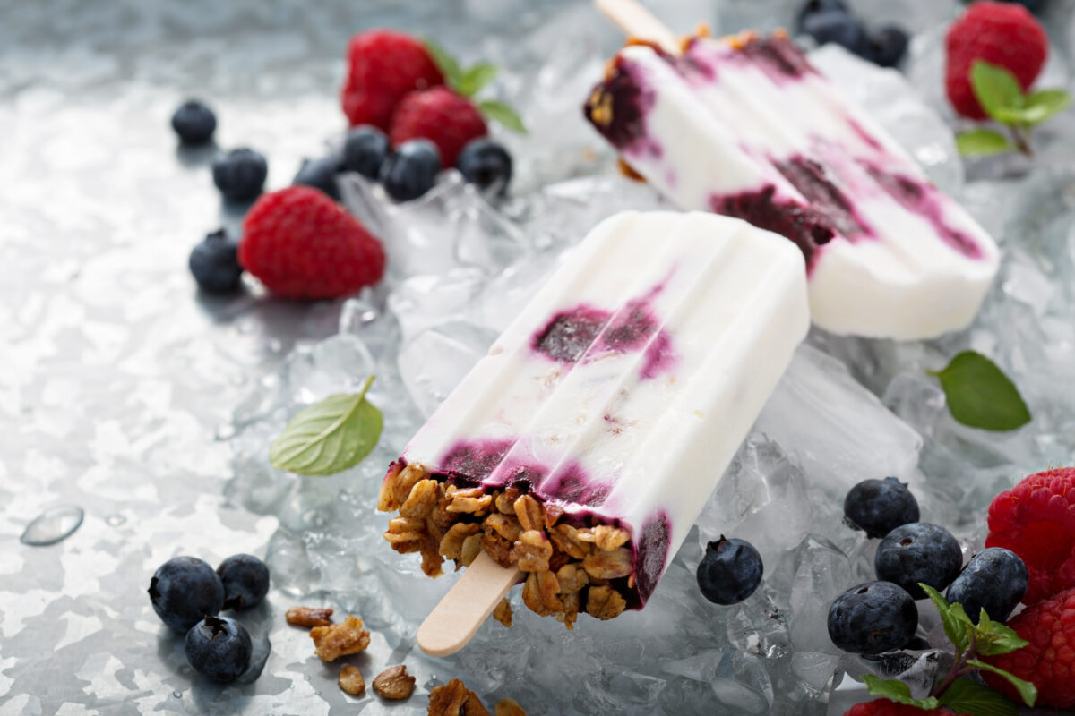 Yogurt, berry and granola breakfast popsicles on a tray