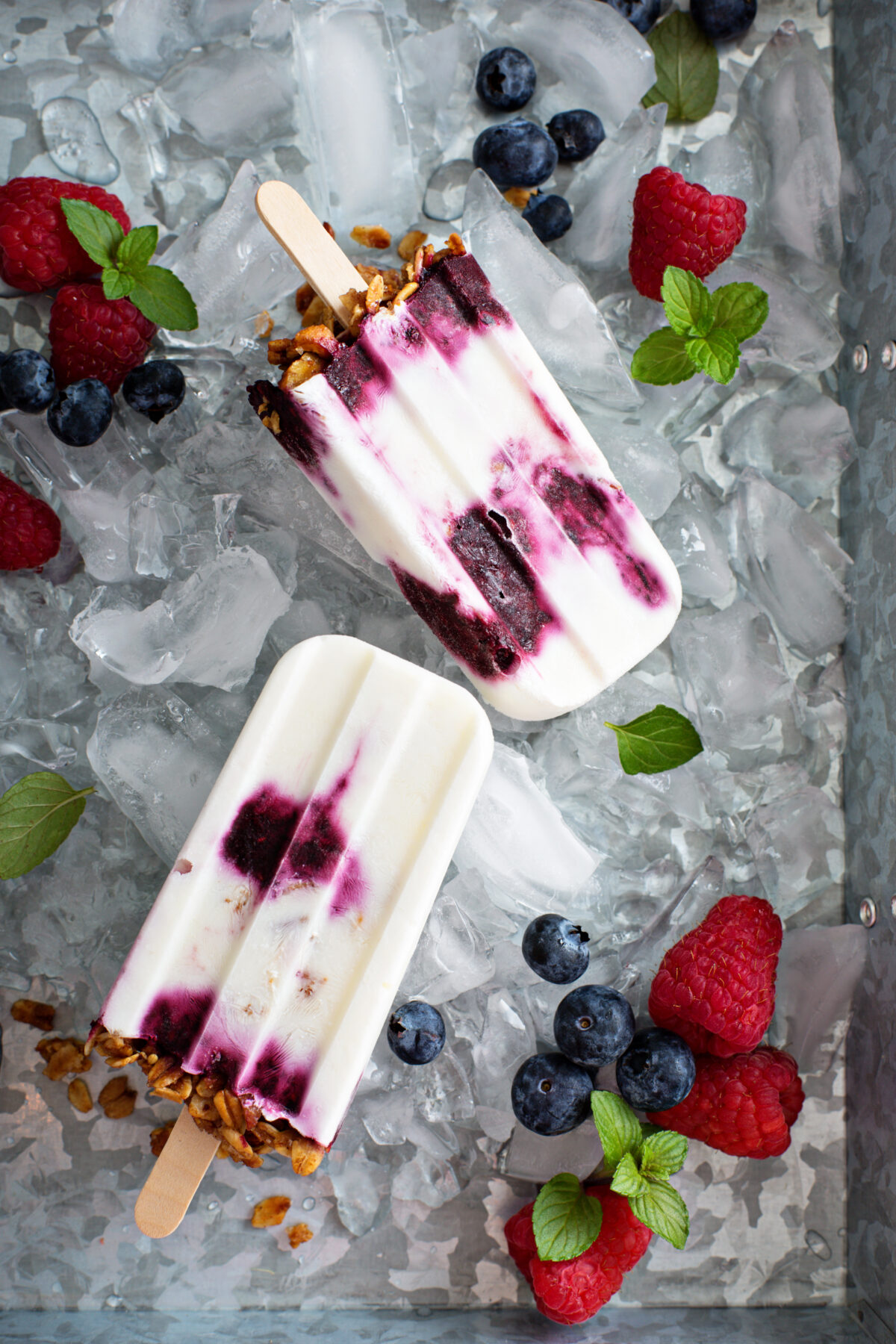 Yogurt, berry and granola breakfast popsicles on a tray