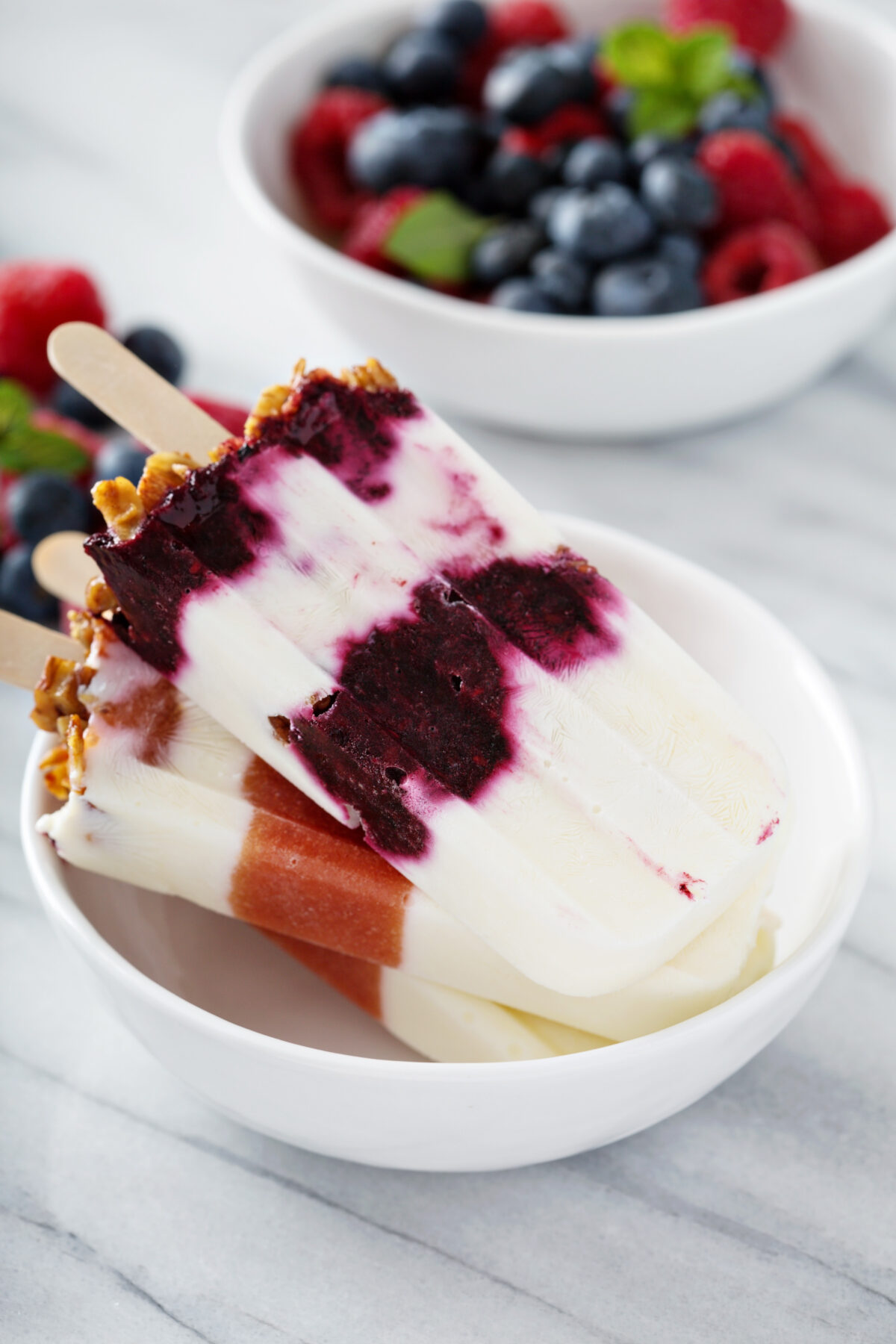 Yogurt, fruit and granola breakfast popsicles in a bowl