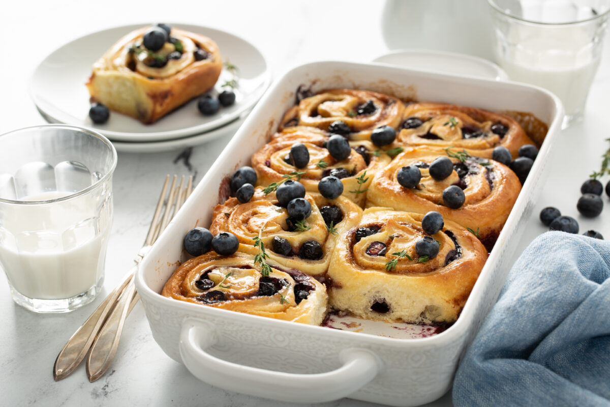 fresh blueberries rolls with a glass of milk and serving forks