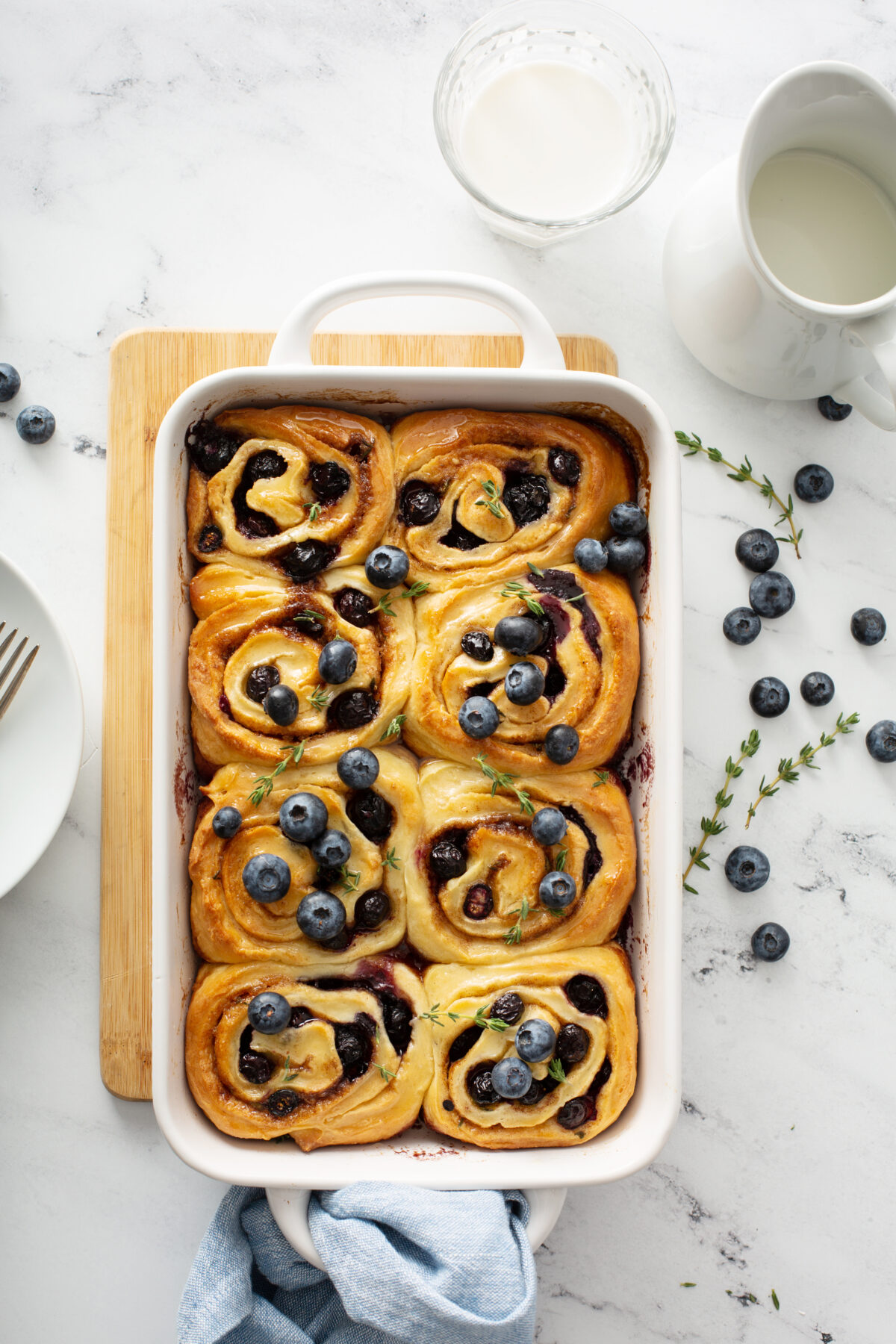 blueberry rolls with fresh thyme in a white baking dish