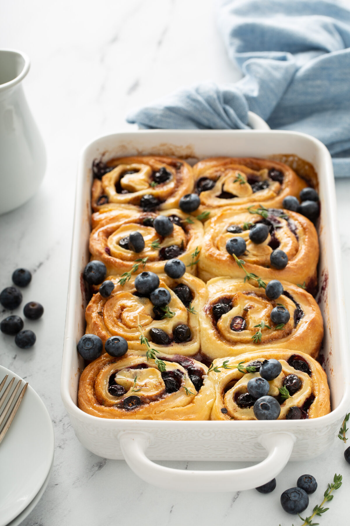 blueberry cinnamon rolls baked uneil golden and topped with fresh blueberries and thyme