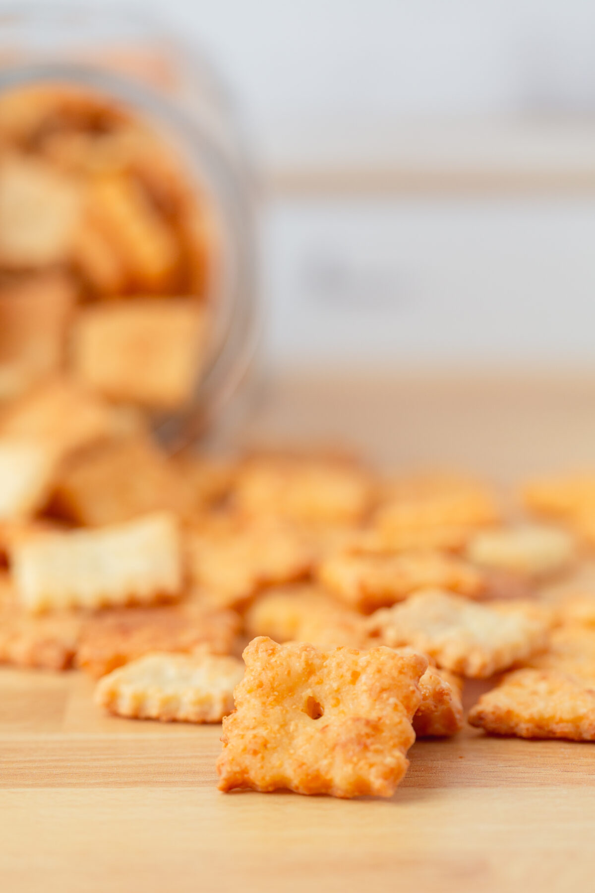 homemade cheese crackers scattered on a wooden counter top