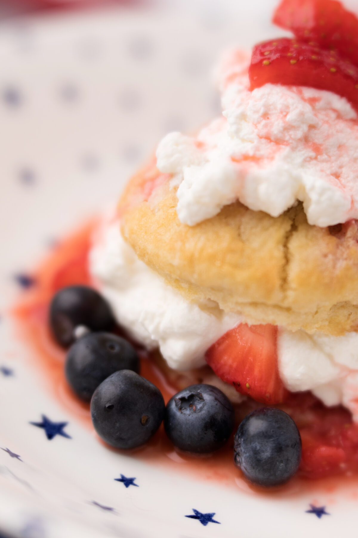 shortcake with strawberries, blueberries and whipped cream on a plate