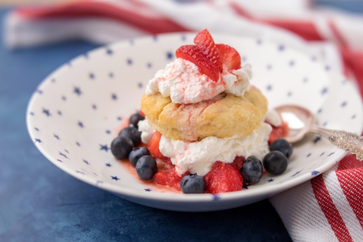 mixed berry shortcakes on a serving plate with whipped cream