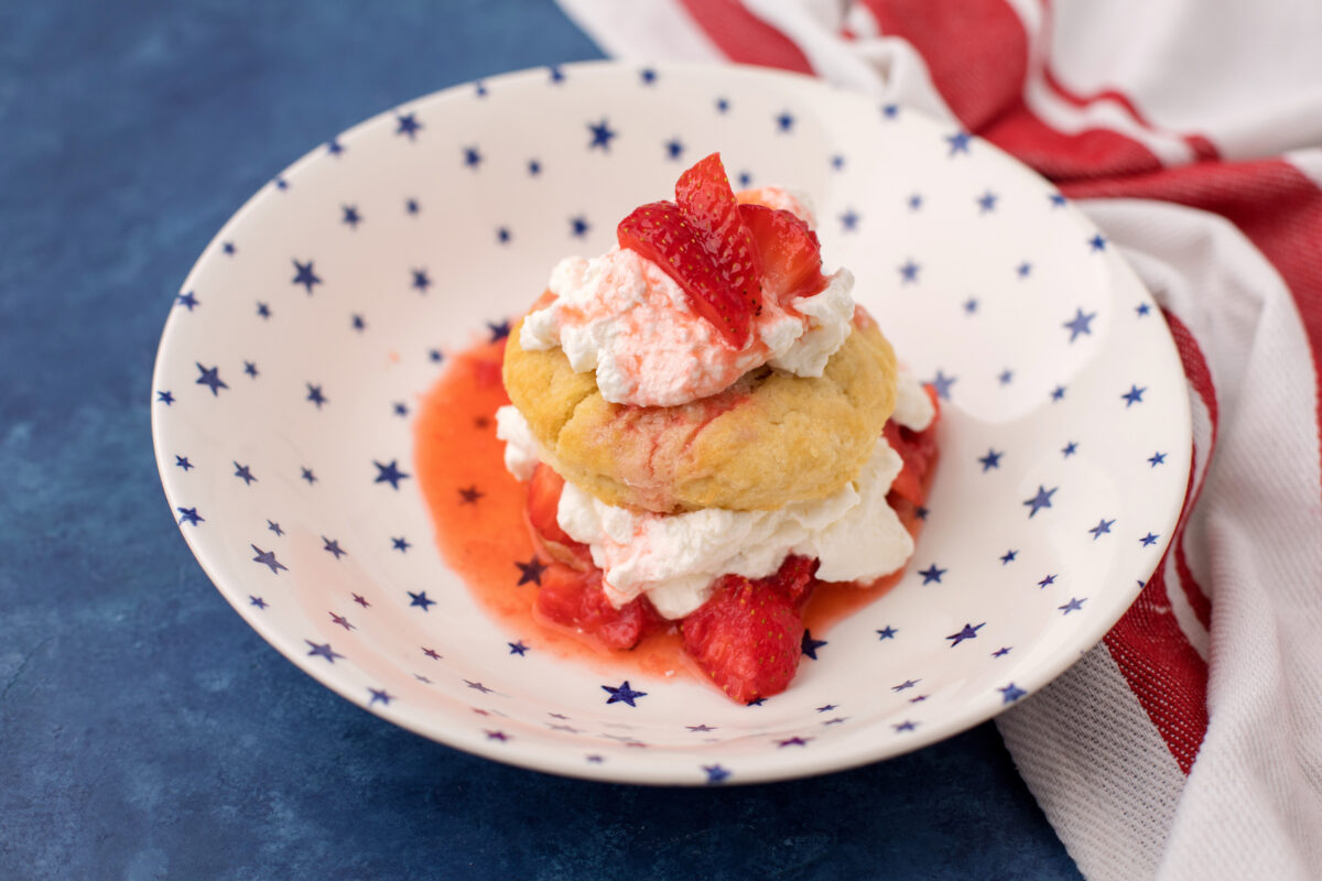 strawberry shortcake on a serving plate with a striped linen