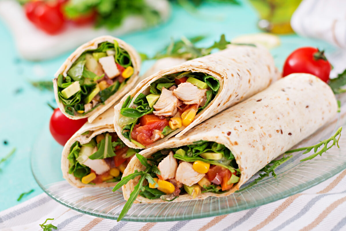 southwest chicken wraps with vegetables on a glass platter close up shot