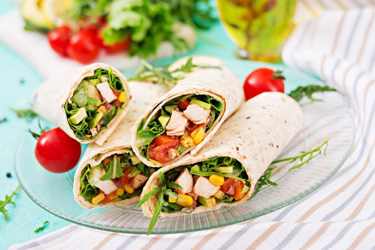 southwest chicken wraps with veggies on a plate with a striped linen