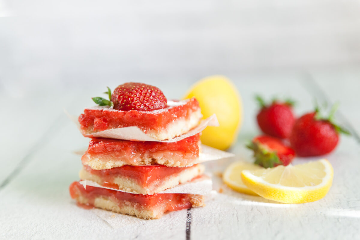 strawberry lemonade bars with fresh lemon slices and topped with fresh berries