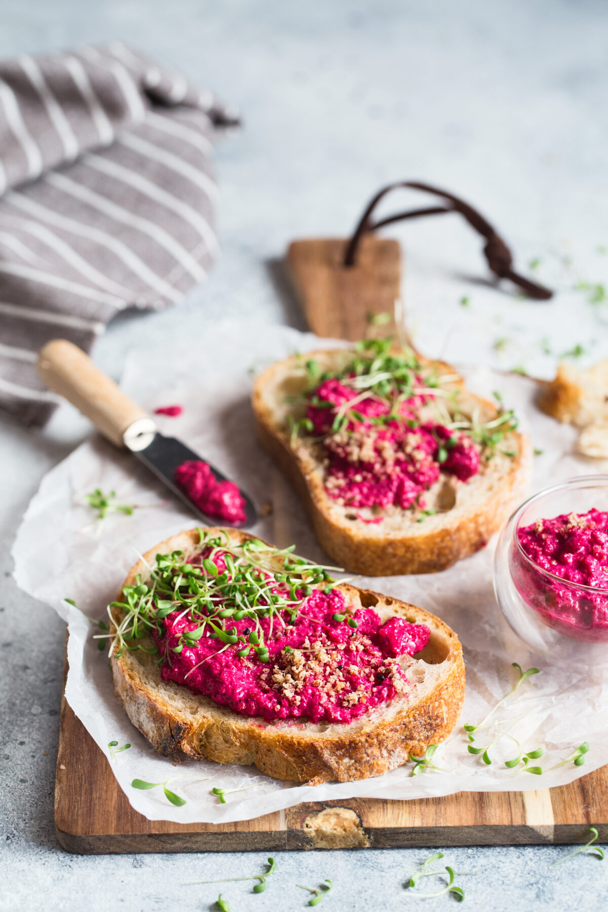 Bruschetta with Beetroot hummus decorated with chopped nuts and microgreen.