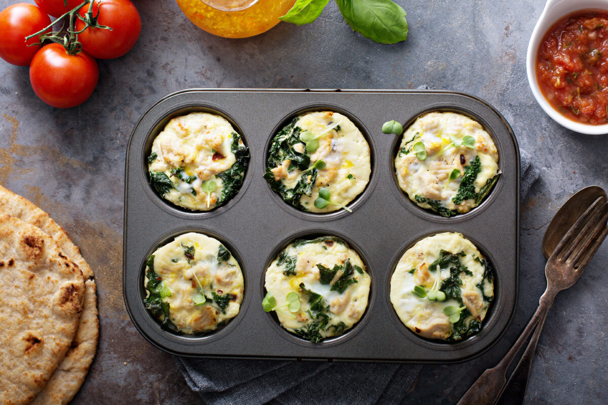 chicken and kale high protein egg muffins in a tin with a side of salsa