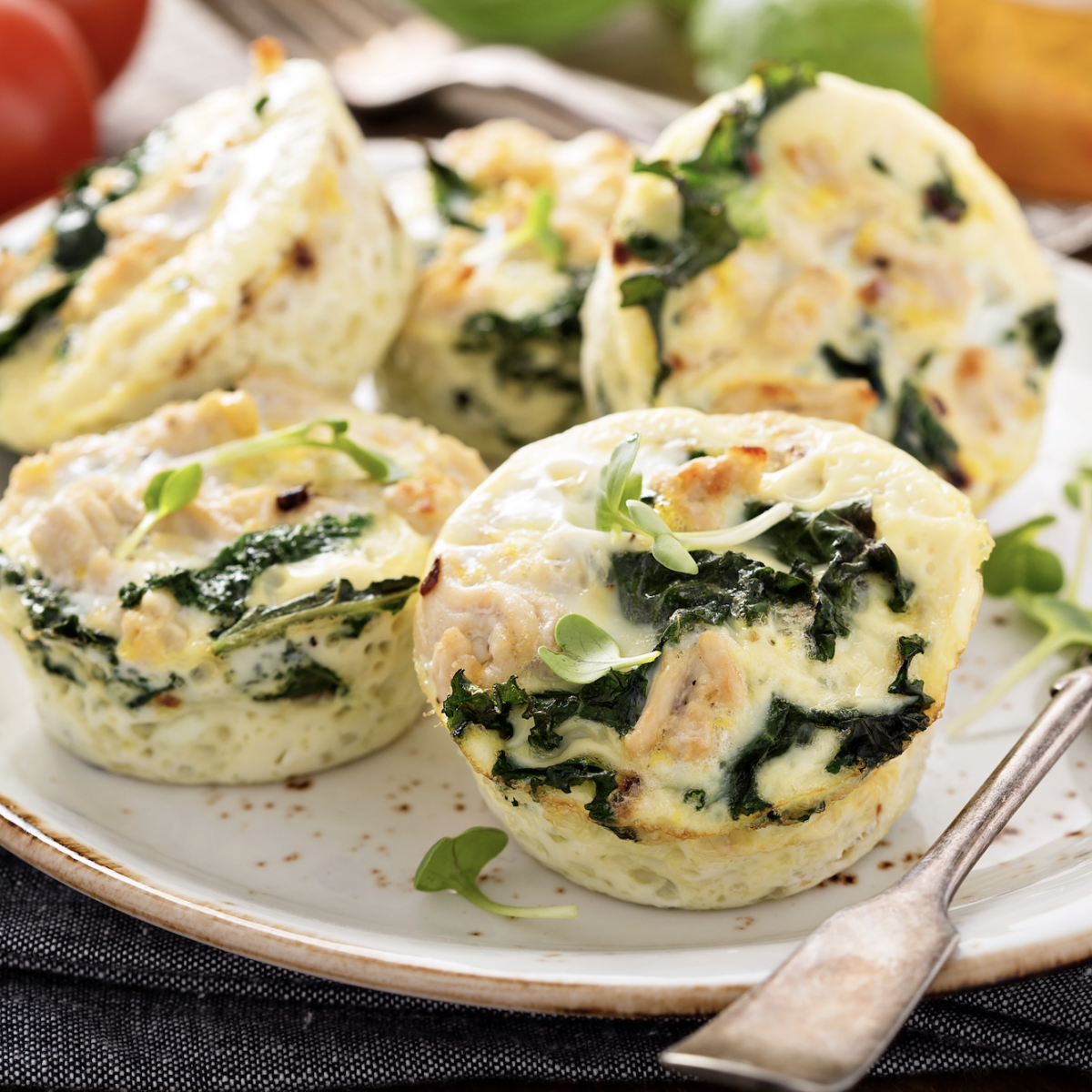 protein egg cups on a serving plate with microgreens and a fork