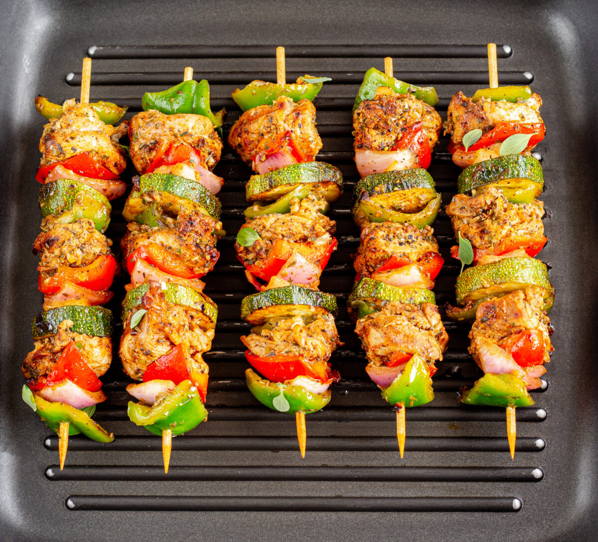 grilled chicken kabobs with veggies on a grill pan