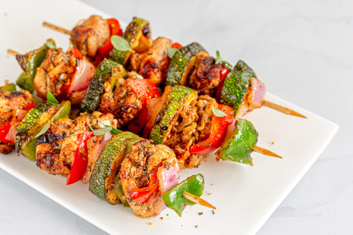 Mediterranean Chicken Kebabs with Zucchini and Bell Peppers on the Skewers Garnished with Oregano Leaves. Greek Chicken