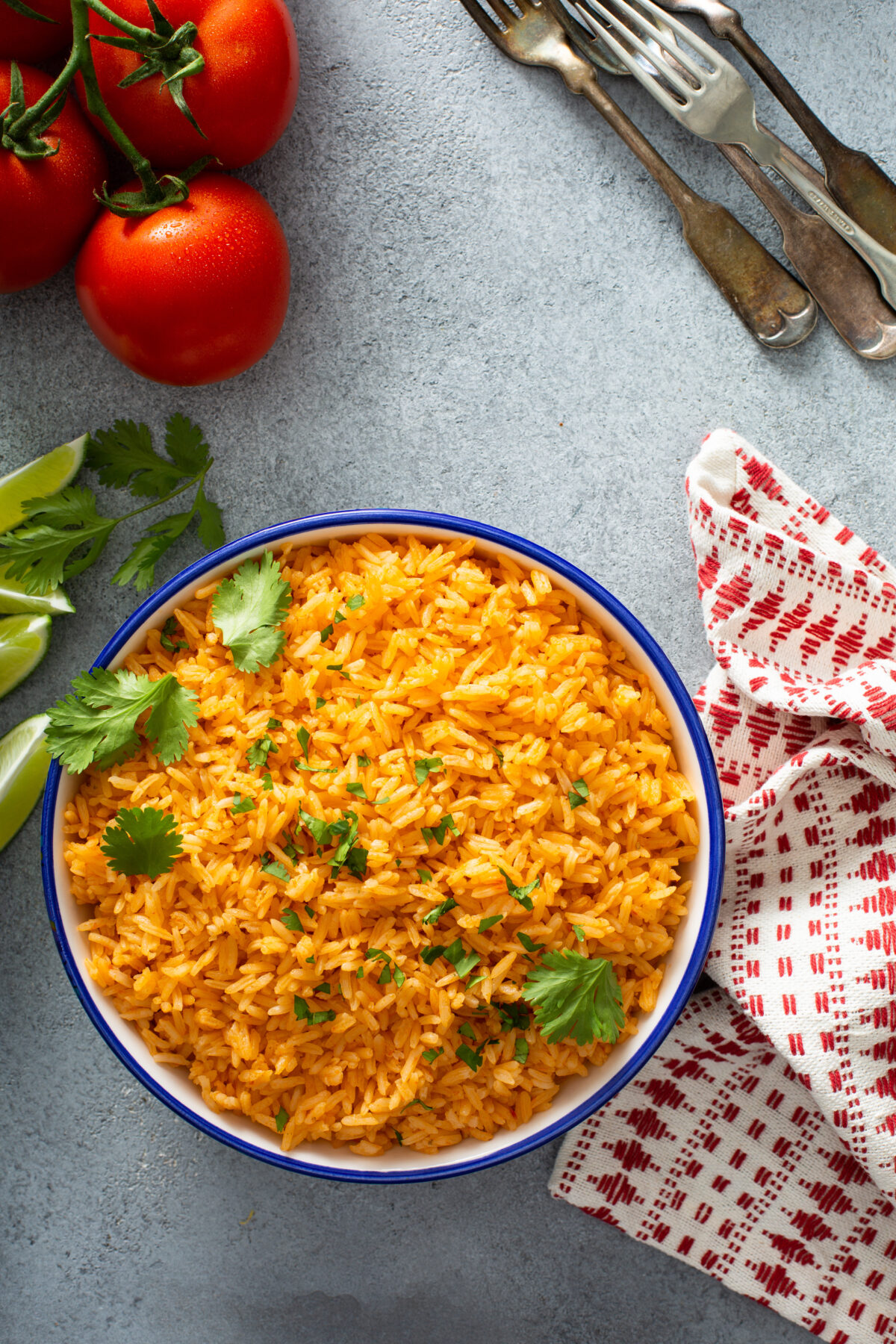 Mexican rice with tomatoes and onion served with cilantro in a serving bowl