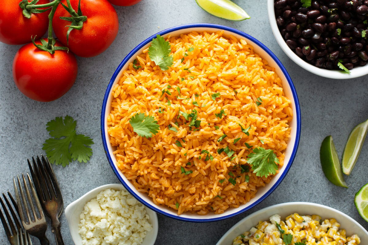 easy mexican rice served with elote and fresh limes