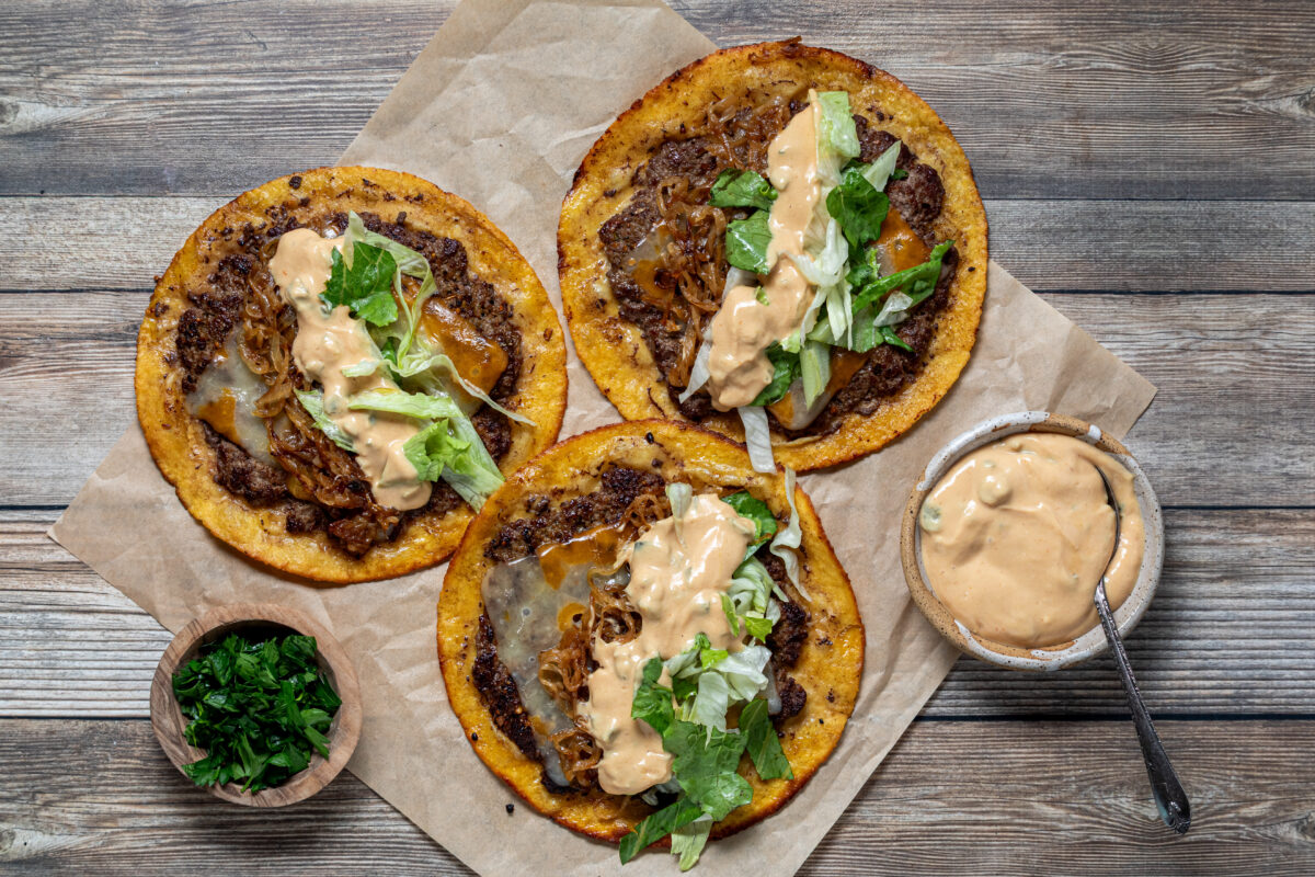 Above view of freshly made smash burger tacos with burger sauce and parsley.