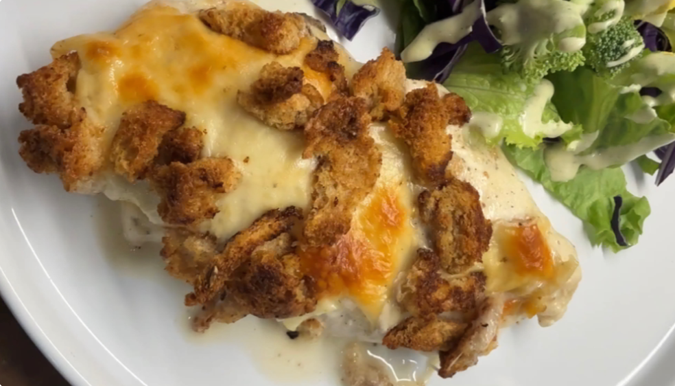 caesar chicken bake with a side salad on a serving plate