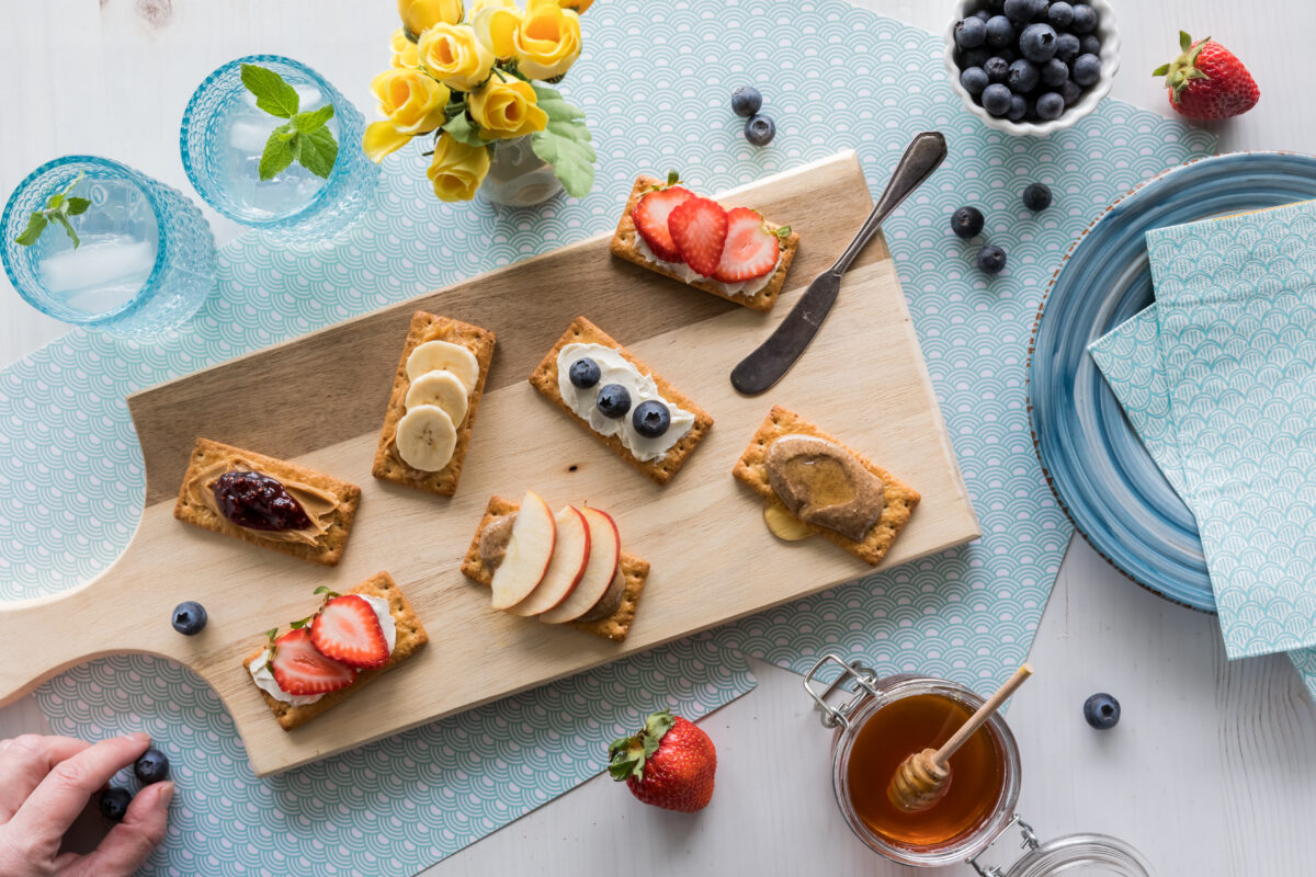 after school snack crackers with various toppings of fresh fruit and cream cheese spread or nut butter.