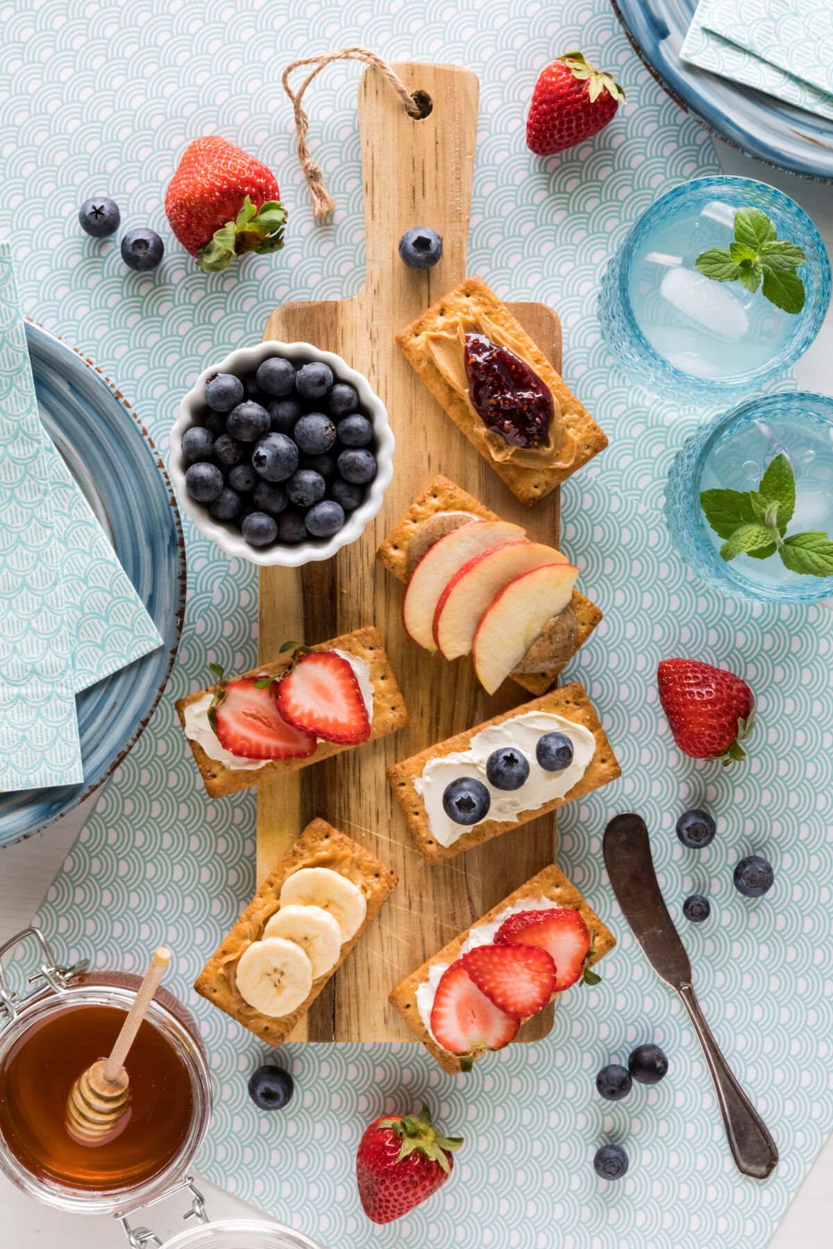 snack crackers with nut butters and fresh fruit spread on a board