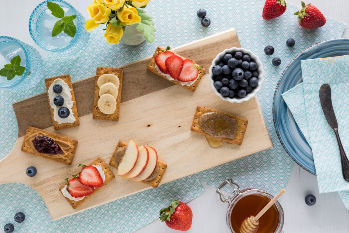 after school snack crackers with an assortment of toppings on a board