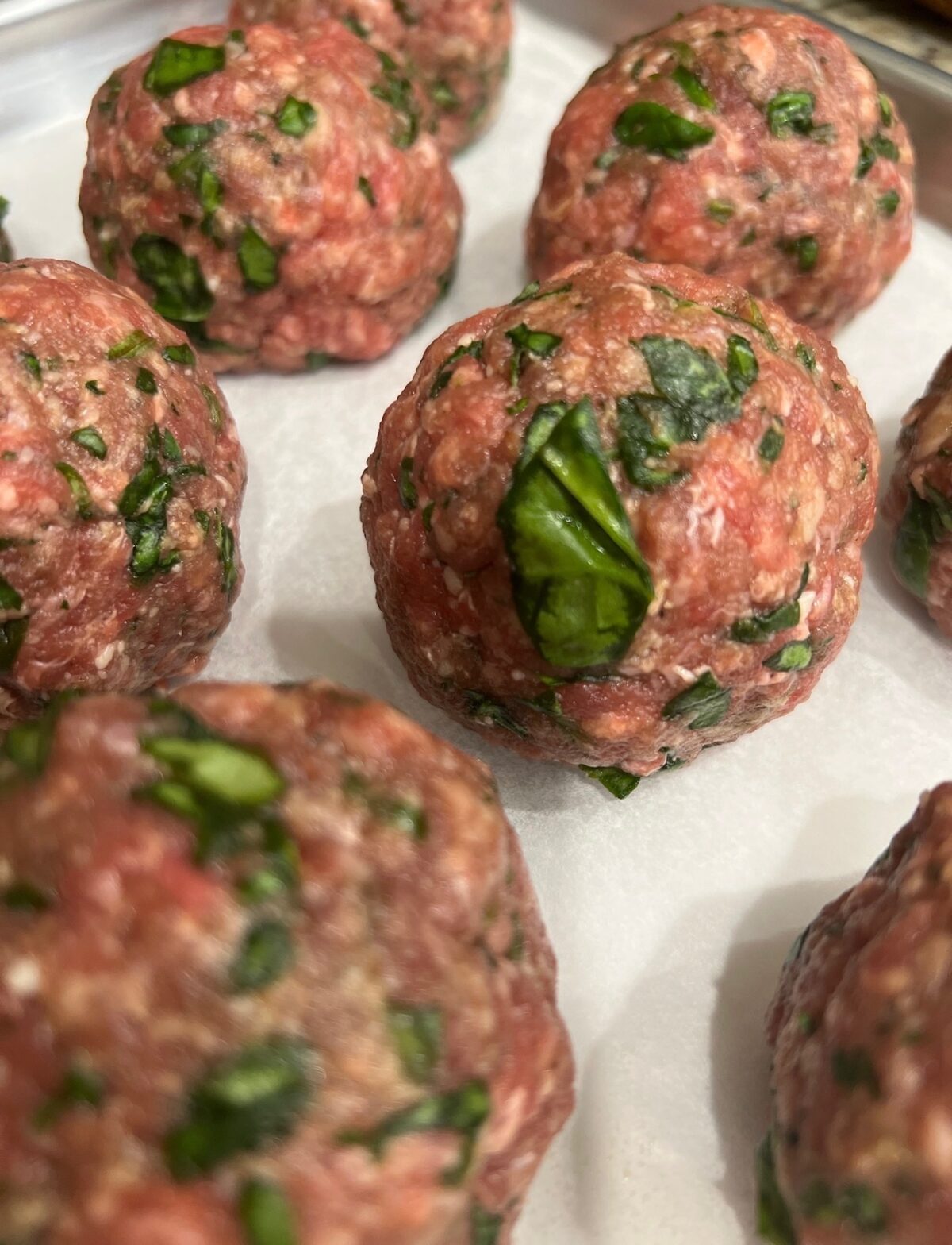 a close up image of high protein meatballs on a baking sheet