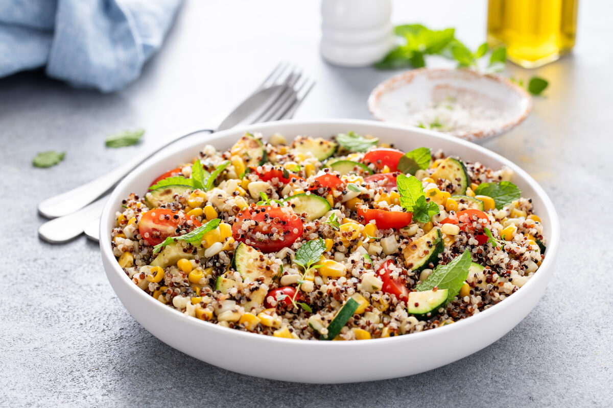 Warm quinoa salad with tomatoes, corn and zucchini with fresh herbs