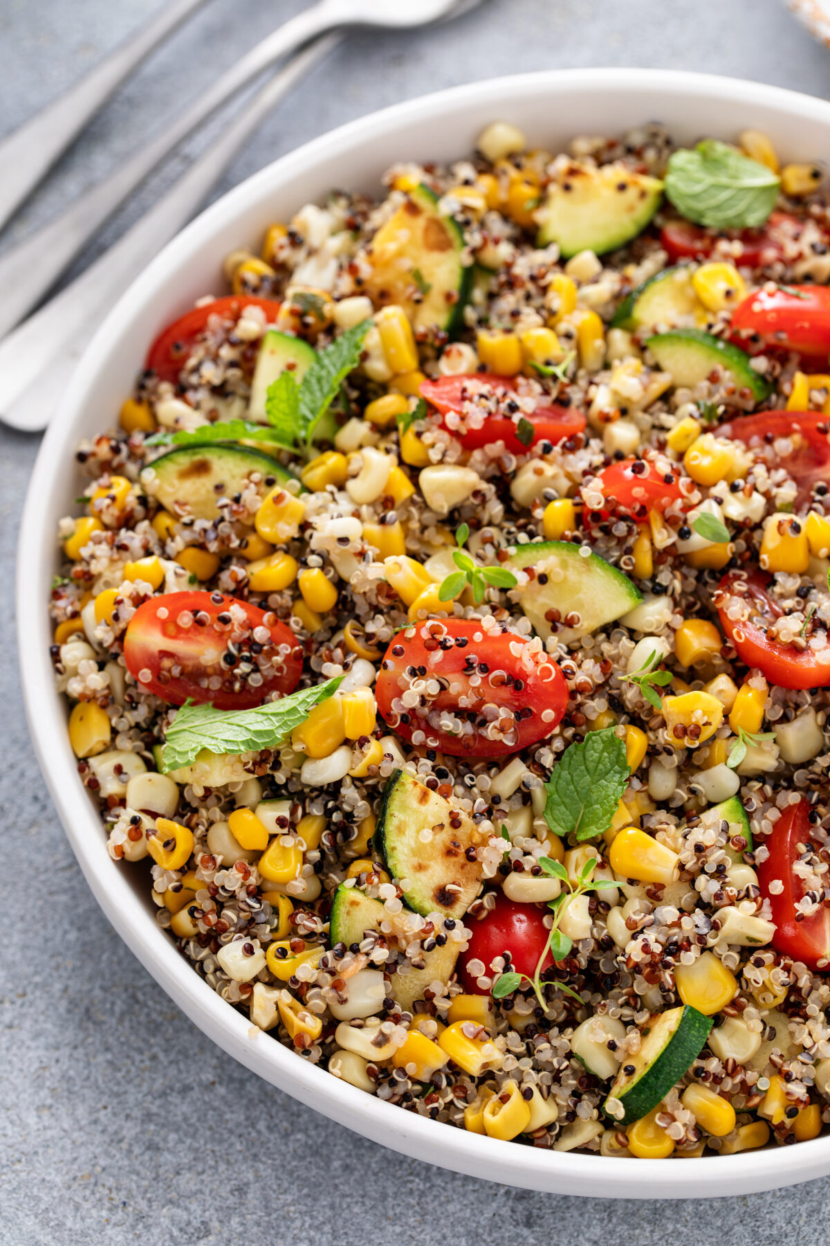 quinoa salad with garden veggies and fresh herbs in a serving bowl