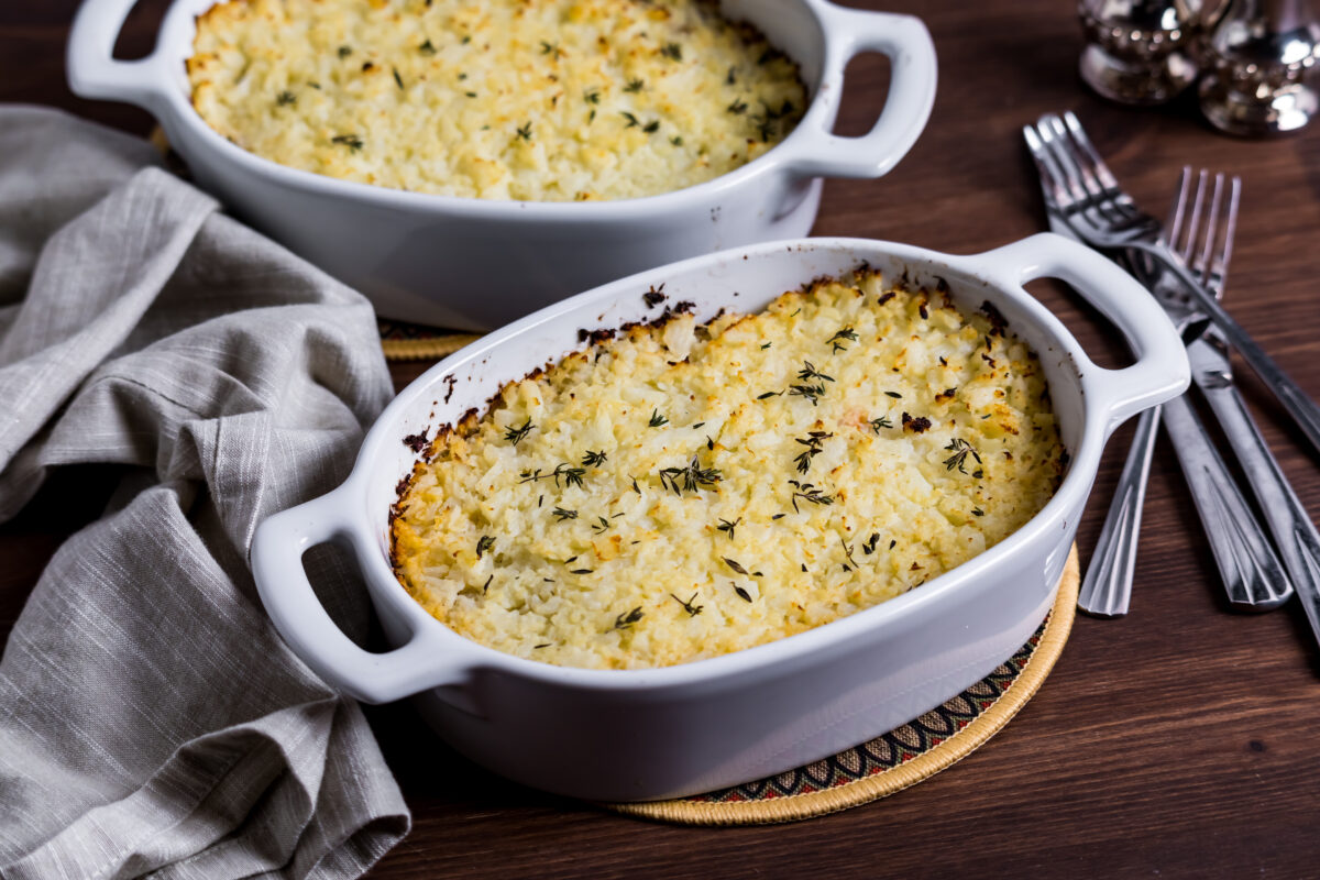Homemade Shepherd's Pie topped with mashed cauliflower and sprinkled with fresh thyme leaves.