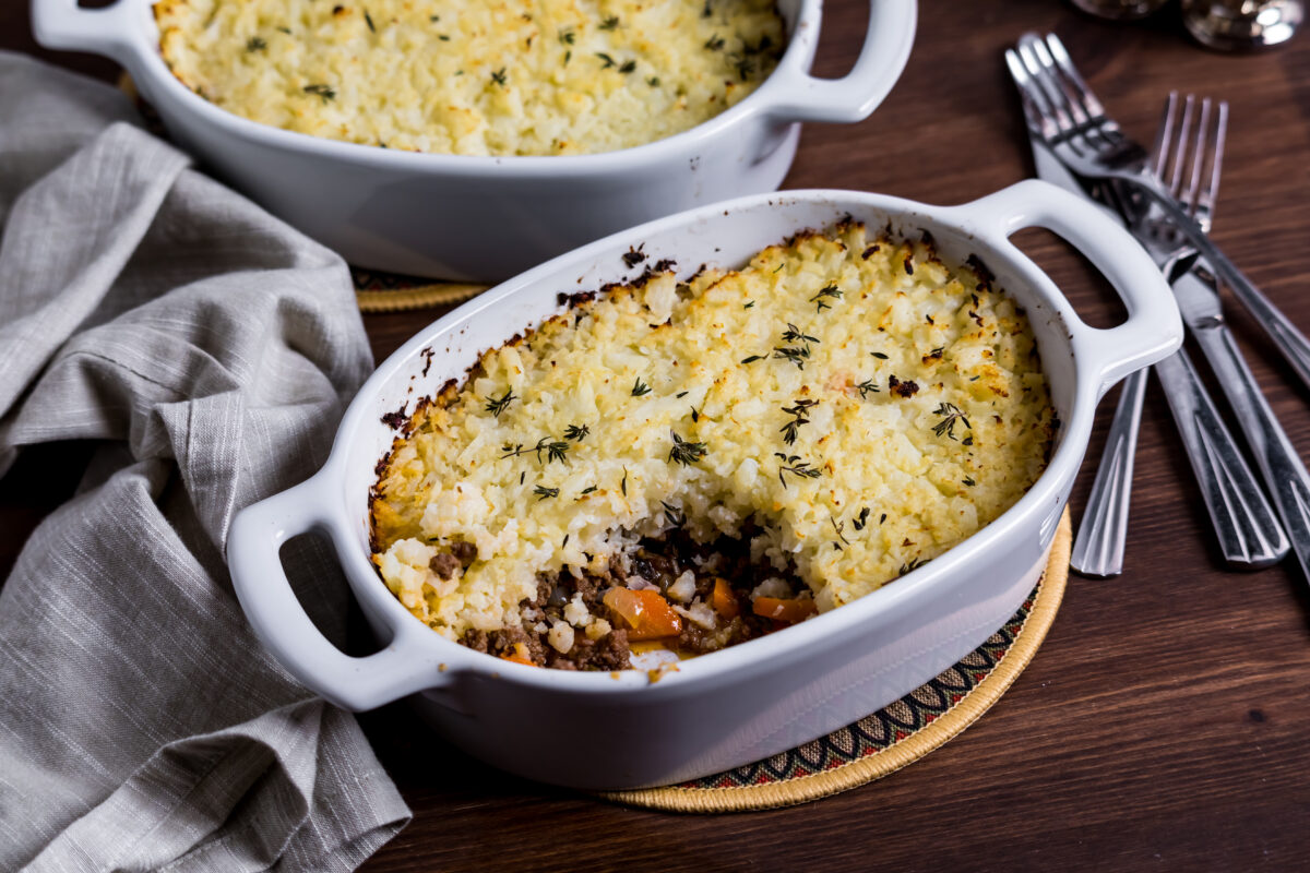 Casserole dishes of homemade cauliflower shepherd's pie, with a slice out of the front one.