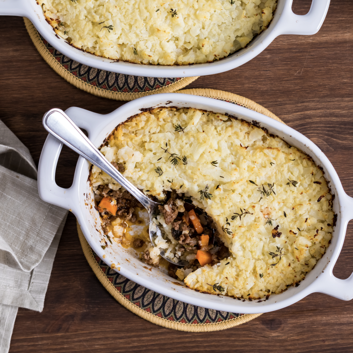 shepherd's pie with cauliflower crust in a baking dish with a scoop removed