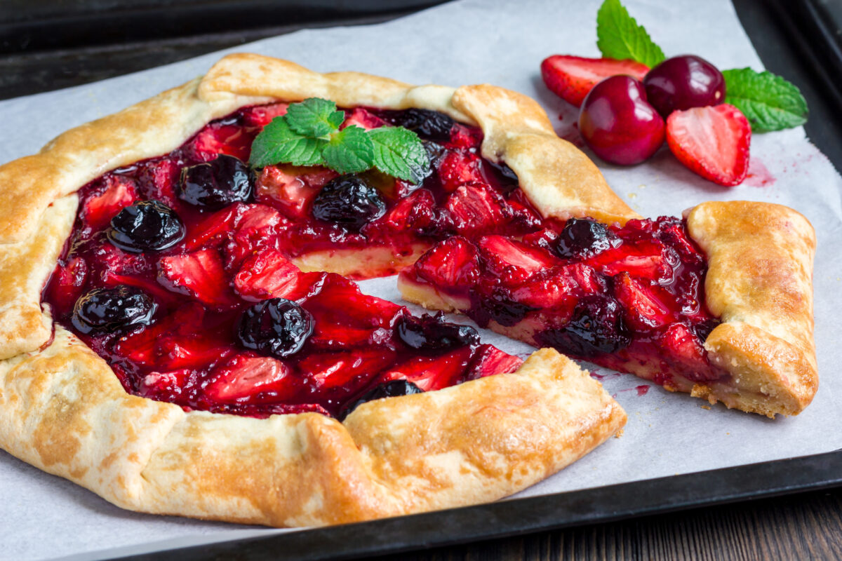 strawberry cherry galette on baking tray with fresh mint garnish