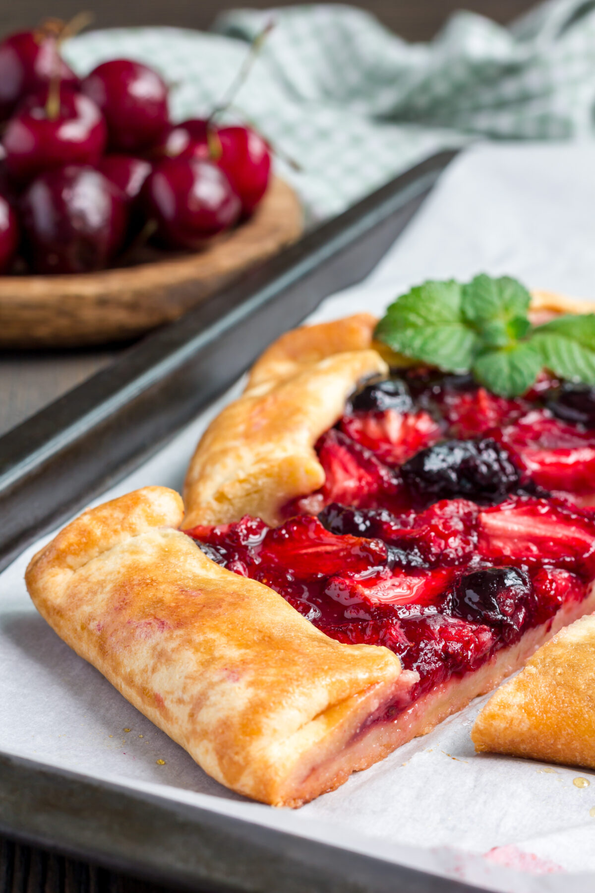 strawberry cherry galette cut into slices on a baking sheet
