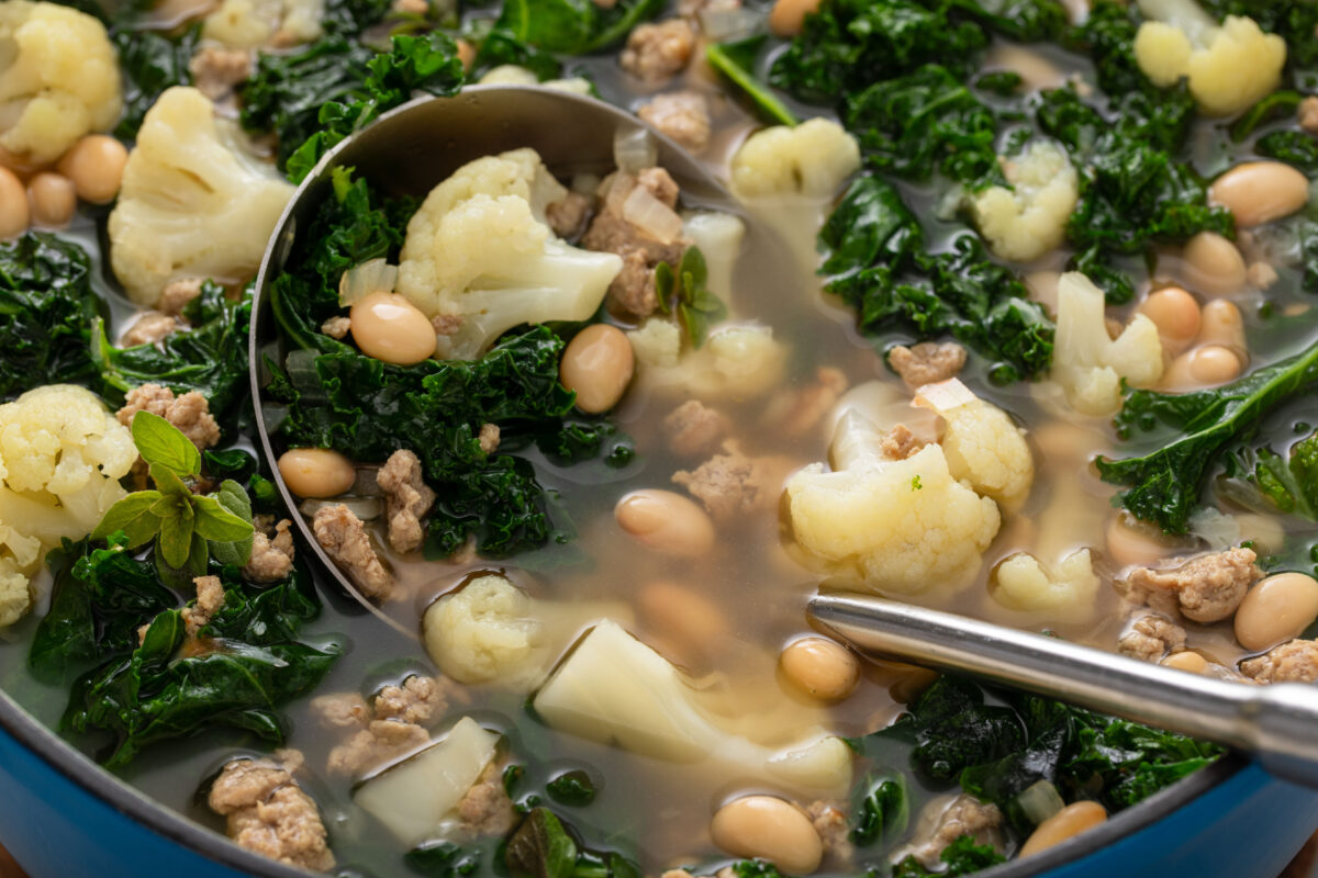 tuscan white bean soup in a pot with a ladle