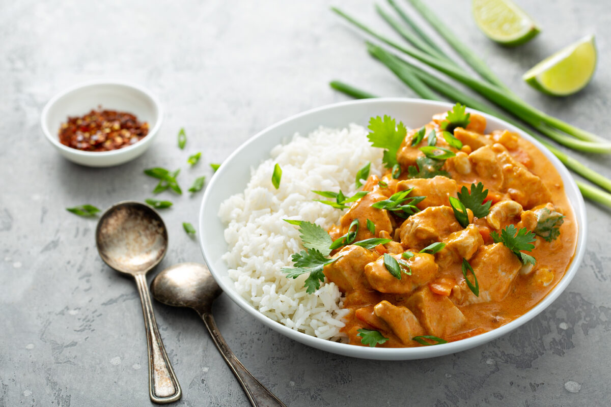 Chicken and cashew red curry with rice and herbs in a serving bowl