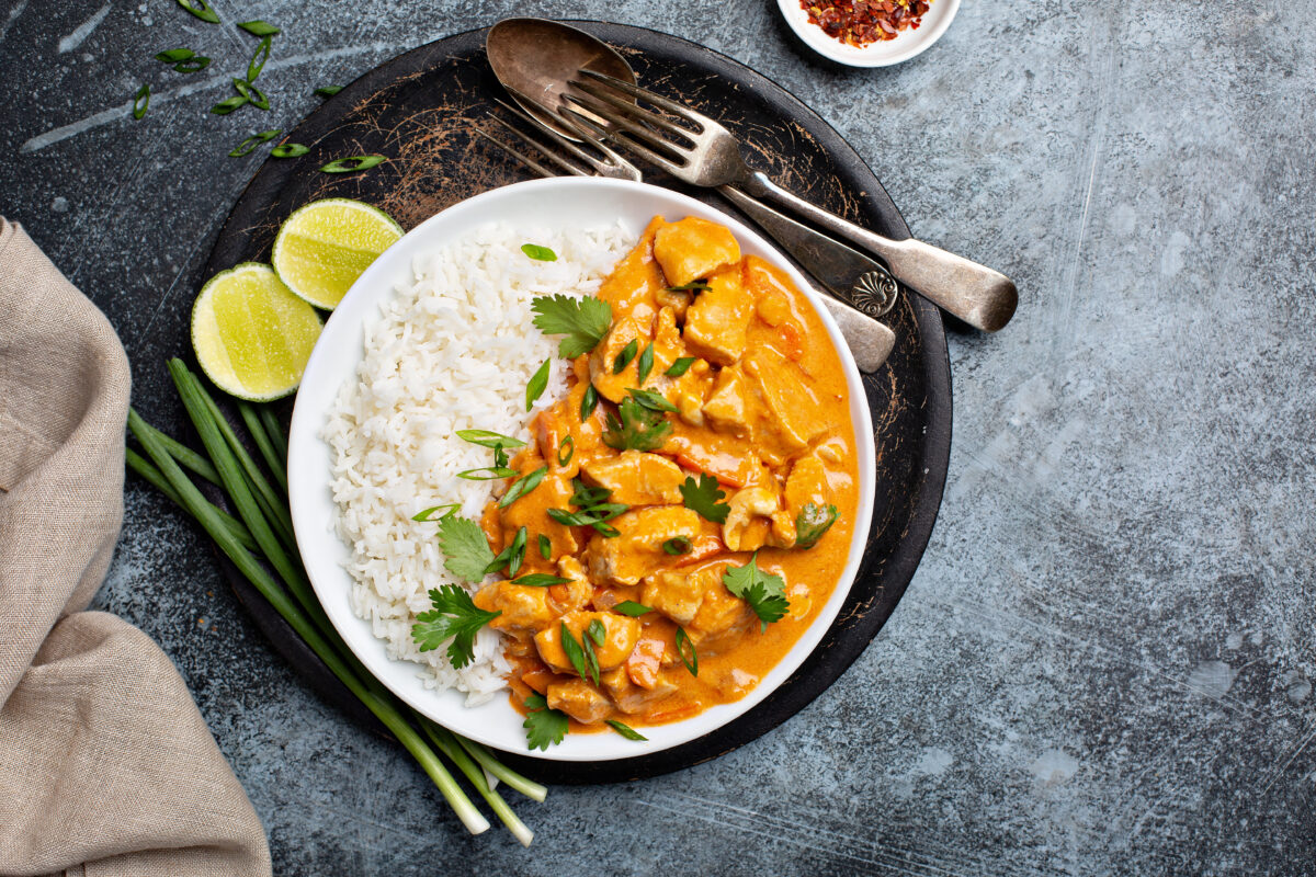 Chicken and cashew red curry with rice and herbs, overhead image with a linen 
